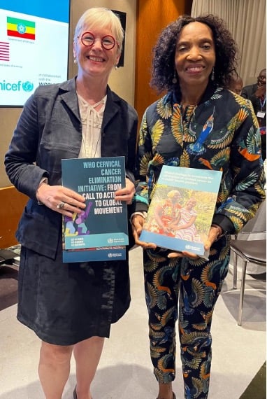 Bente Mikkelsen and colleague holding a copy of the CCEI brochure